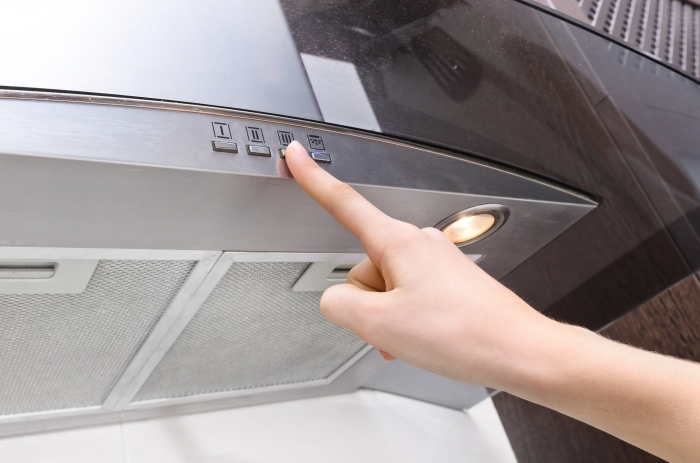 Cooker hood with someone pressing a button