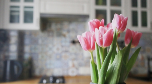 A bouquet of pink tulips on a background of bright kitchen.