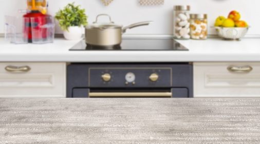 Wooden table on defocused kitchen bench with oven background