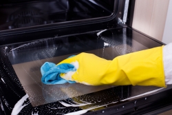 Person cleaning an oven