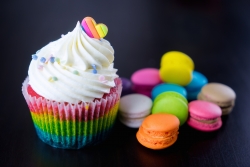 Colourful rainbow valentine cupcake with macaron.