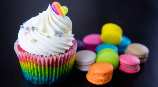 Colourful rainbow valentine cupcake with macaron.