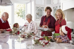 Extended Family Group Preparing Christmas Meal In Kitchen