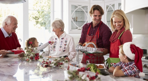 Extended Family Group Preparing Christmas Meal In Kitchen