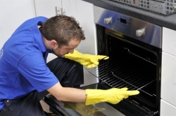 Ovenclean specialist putting oven rack into oven