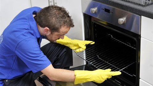 Ovenclean specialist putting oven rack into oven