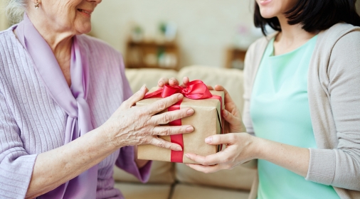 Young woman giving package with surprise to her mother