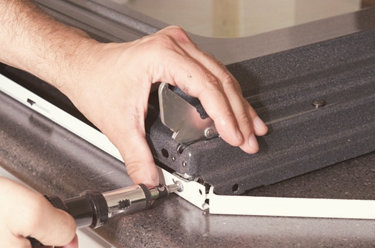 a person fixing an oven window