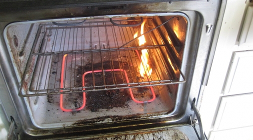 an oven on fire because it is dirty